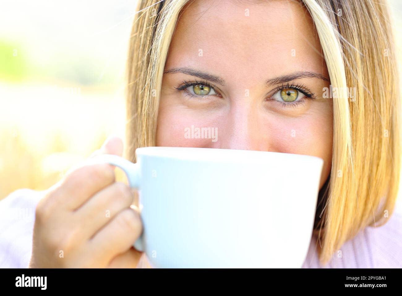Adolescent heureux avec des yeux de beauté tenant une tasse de café Banque D'Images