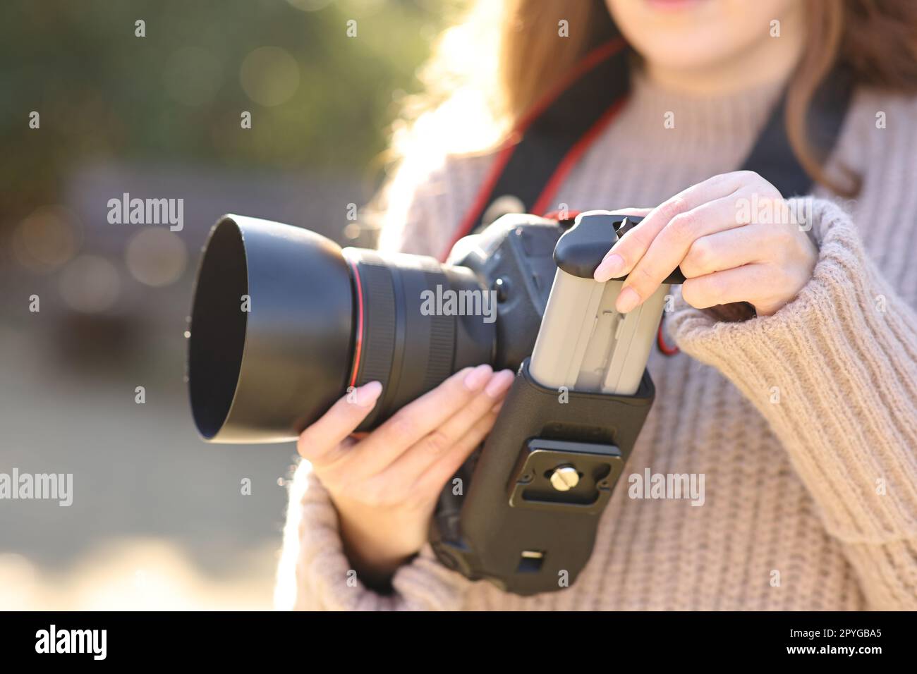 Photographe changeant la batterie sur l'appareil photo reflex numérique Banque D'Images