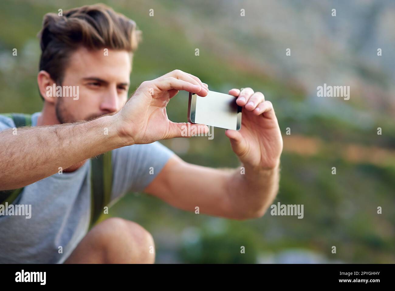 Prendre quelques photos pour les peeps de retour à la maison. un beau jeune homme prenant des photos pendant la randonnée. Banque D'Images