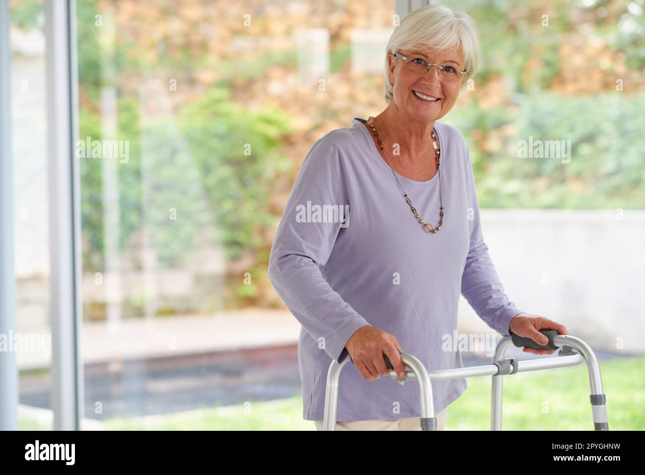 Tout le soutien dont j'ai besoin pour une vie active. Portrait d'une femme âgée à l'aide d'un marcheur orthopédique, qui a l'air positive. Banque D'Images