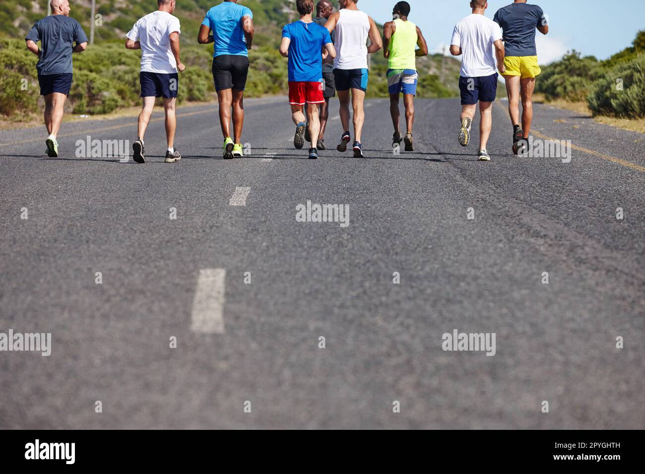 Bonne compagnie en marche. Vue arrière d'un groupe de coureurs masculins pendant un marathon. Banque D'Images