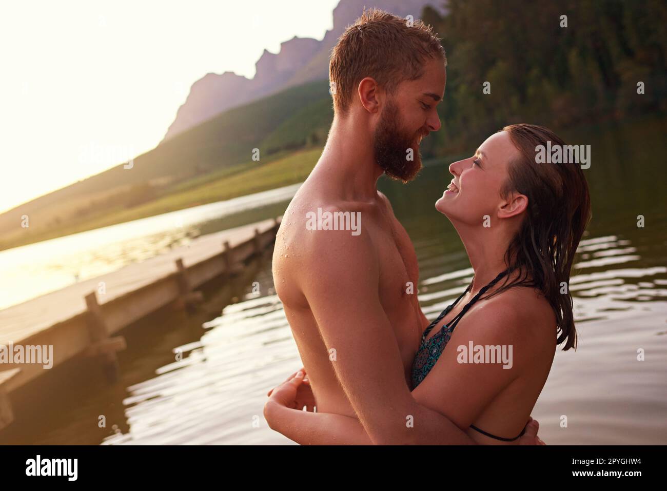 Ne vous laissez jamais aller... un jeune couple affectueux qui s'embrasse en nageant dans un lac. Banque D'Images