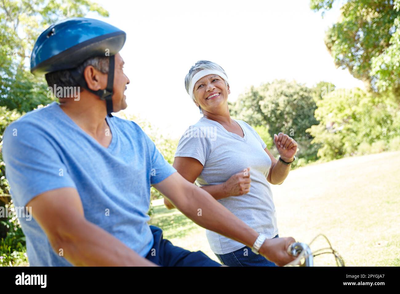 Ensemble pour toujours dans l'amour et la forme physique. un heureux couple senior qui va pour une balade à vélo et un jogging ensemble en plein air. Banque D'Images