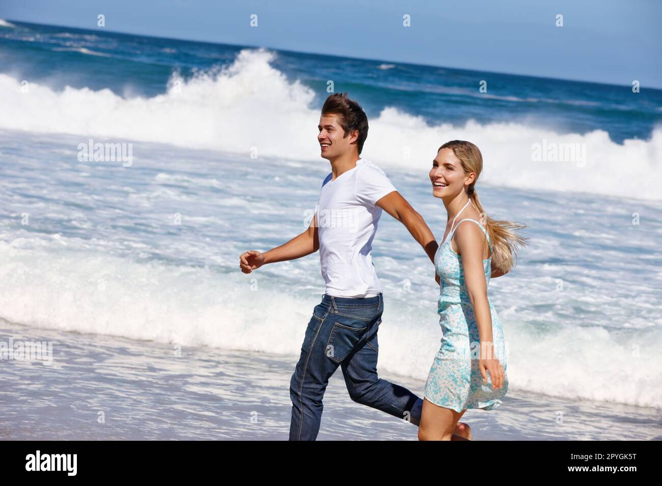 Faisons de cet été un souvenir inoubliable. un jeune couple heureux qui profite d'une promenade le long de la plage. Banque D'Images