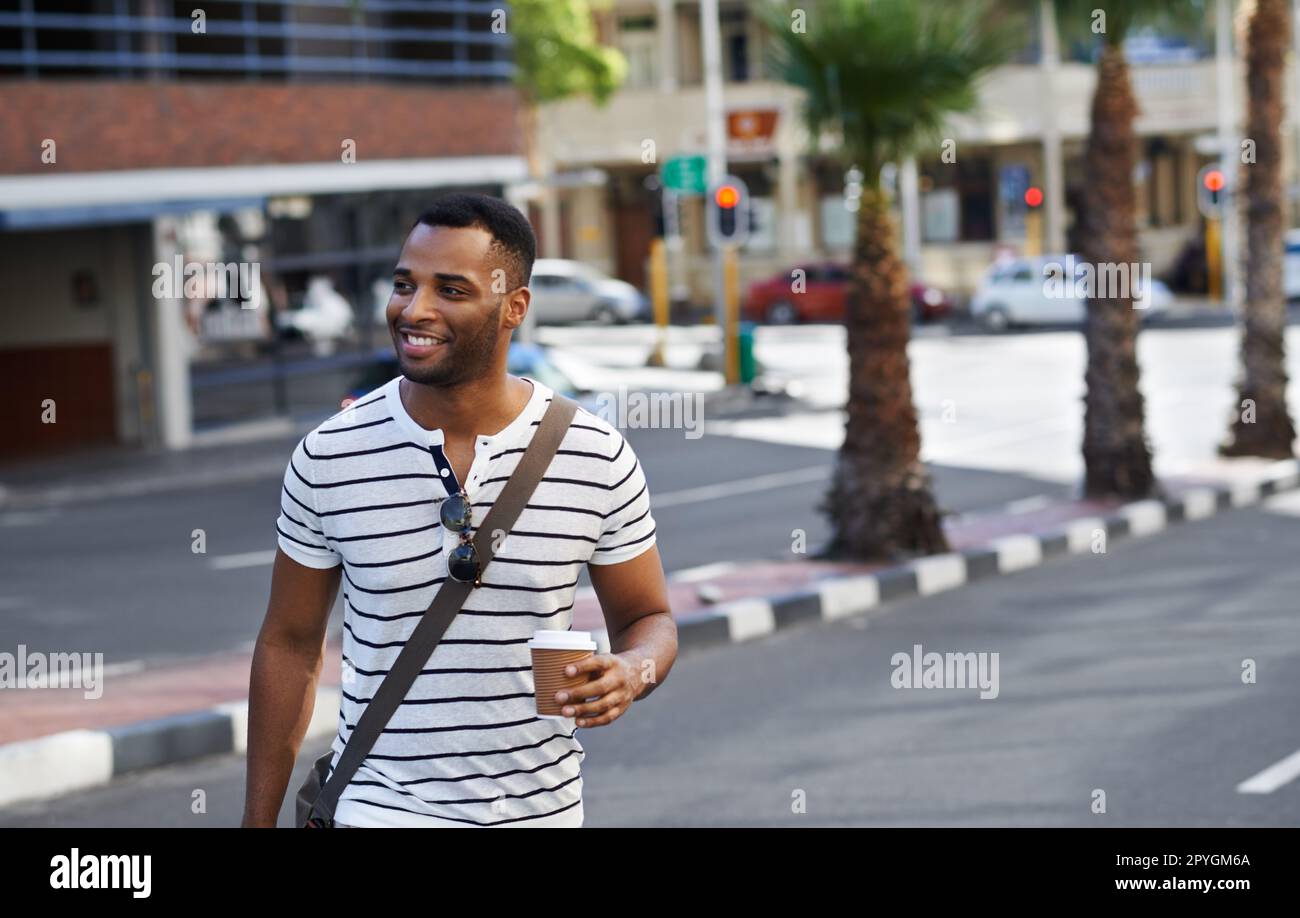 Style urbain en déplacement. Un beau homme d'affaires afro-américain dans la ville alors qu'il est en route pour travailler. Banque D'Images