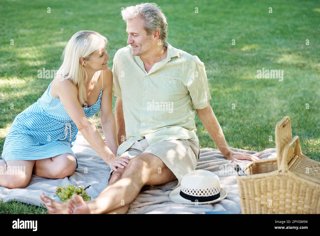 Faire le temps de garder le romantisme vivant. Un mari et une femme souriants qui profitent d'un pique-nique tranquille dans le parc. Banque D'Images