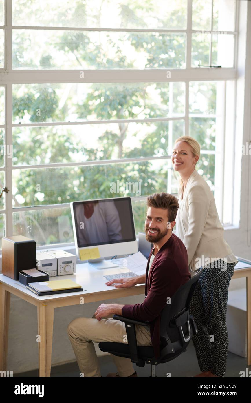 Trouvez l'espace idéal pour une équipe positive. Des collègues hommes et femmes dans un espace de bureau décontracté souriant à la caméra. Banque D'Images