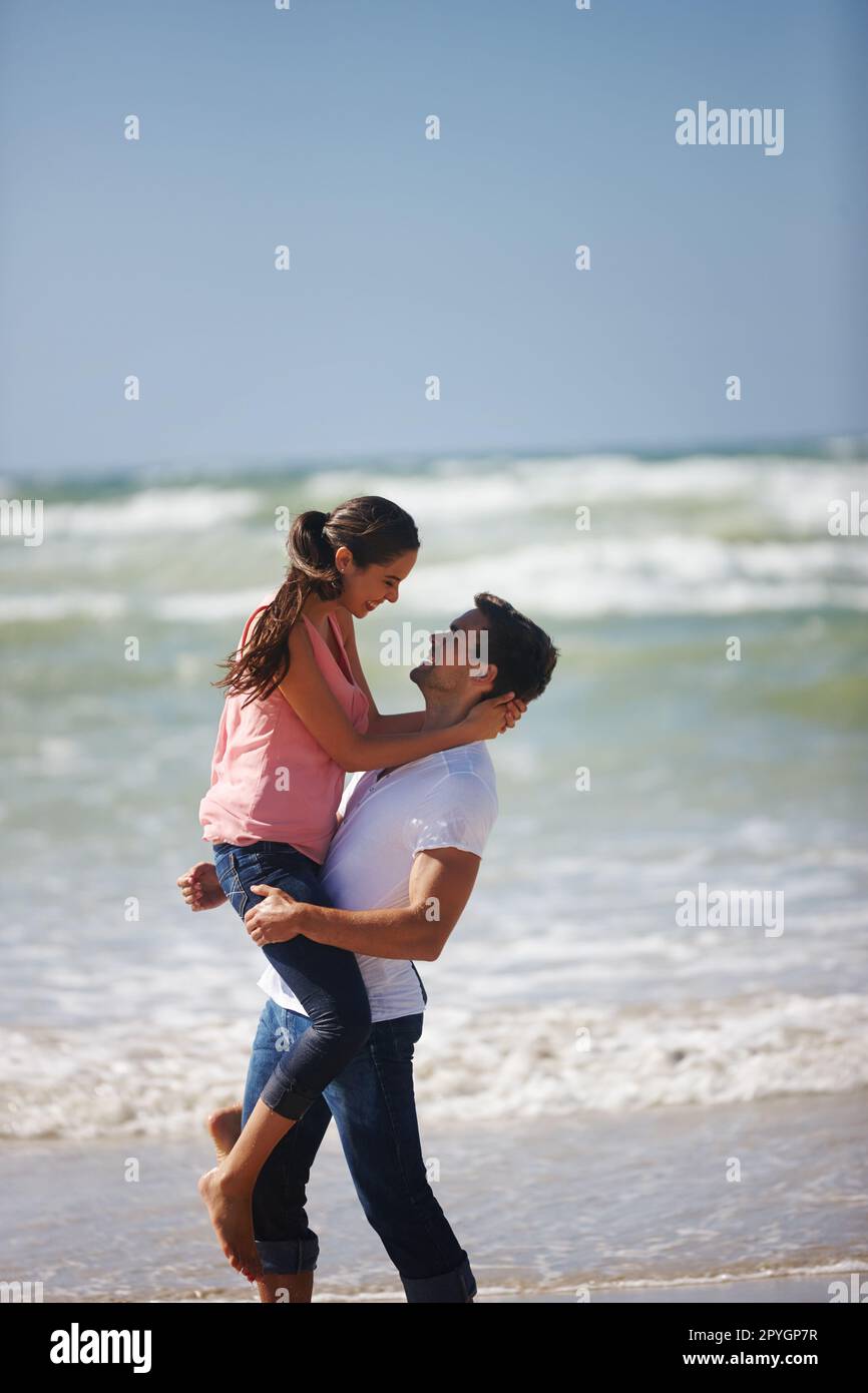 Mon cœur est parfait, parce que vous êtes à l'intérieur. un jeune couple aimant jouant sur la plage. Banque D'Images