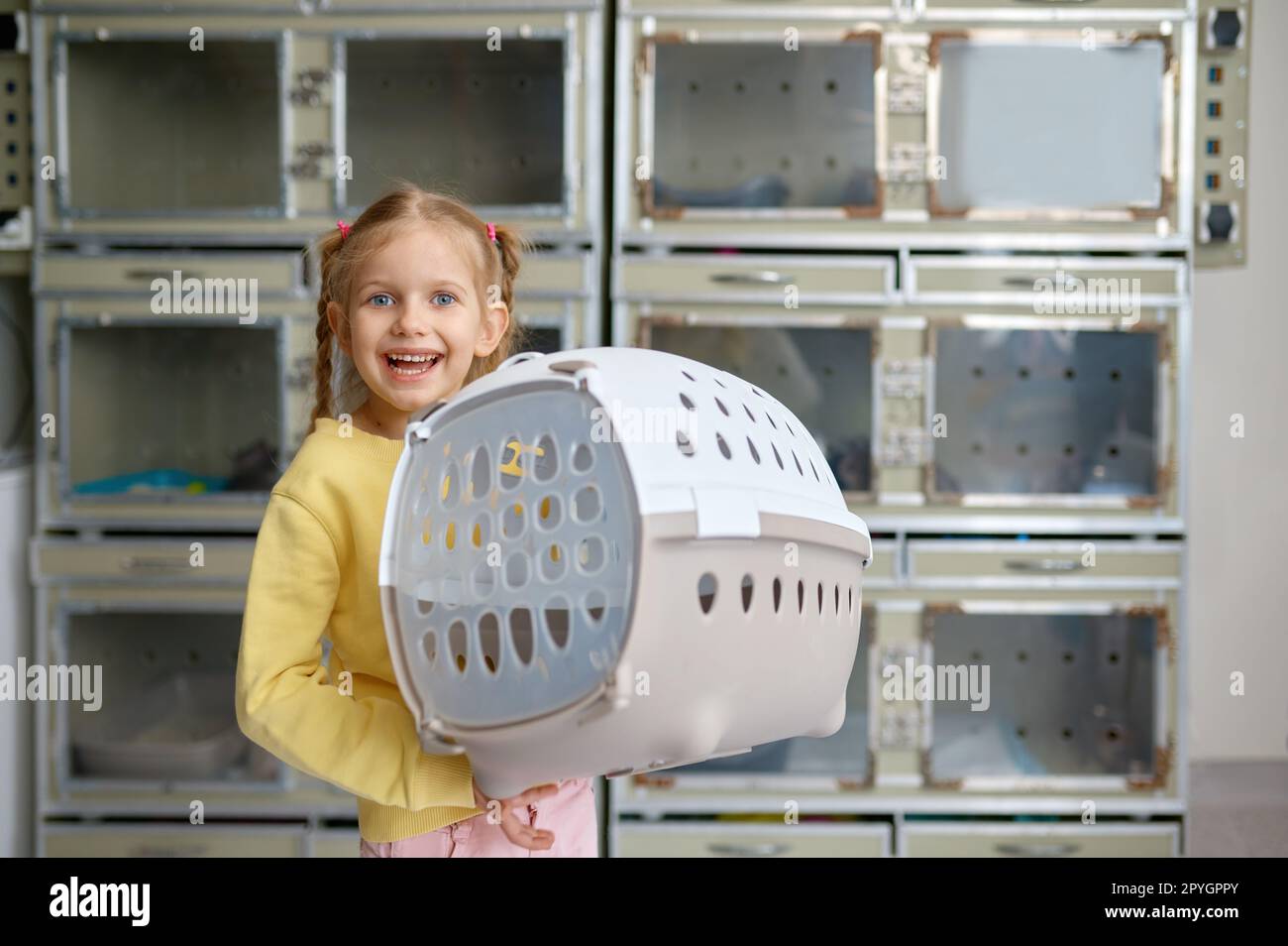 Portrait de petite fille tenant cage avec nouvel animal acheté à la boutique vétérinaire Banque D'Images