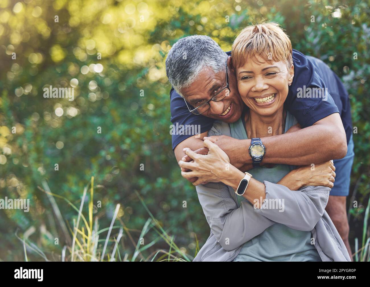 La nature, l'amour et l'homme serrant sa femme avec soin, bonheur et affection lors d'une promenade en plein air. Heureux, romance et portrait d'un couple de personnes âgées à la retraite embrassant dans la forêt, les bois ou le parc. Banque D'Images