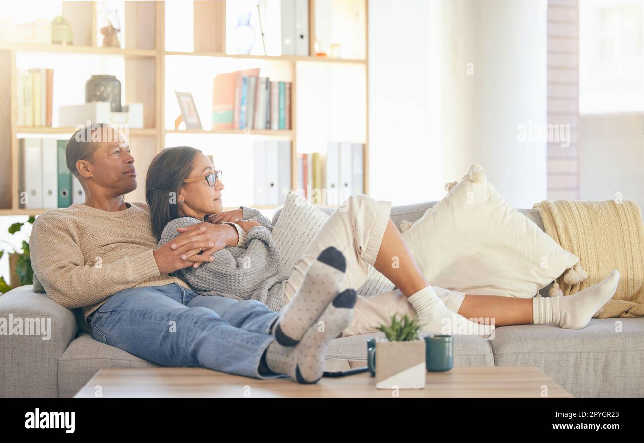 Couple senior, se détendre et canapé pour câliner, penser ou souvenir de la vie, mémoire d'amour ou de liaison dans le salon à la maison. Homme mature, vieille femme et embrasser sur le canapé-lit pour la vision, les soins ou le soutien en Floride Banque D'Images