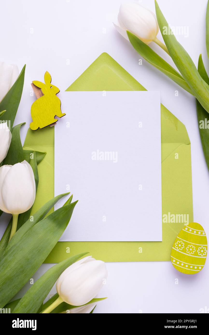 Modèle pour carte de vœux de Pâques. Carte vierge avec enveloppe et bouquet de tulipes blanches Banque D'Images
