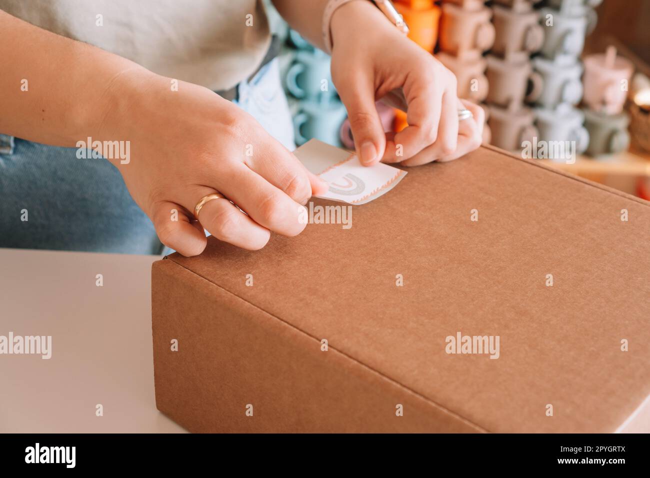 Photos recadrées mains de femme d'affaires emballage, préparant le colis pour le paquet de livraison à l'acheteur. Purshase de vaisselle pour bébé en silicone Banque D'Images