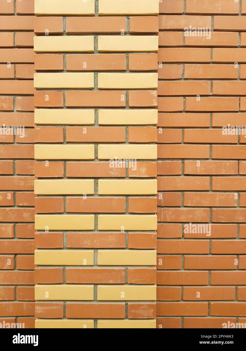 La texture moderne d'un mur de briques orange avec un ornement de briques jaunes est le matériau de fond de la construction industrielle Banque D'Images