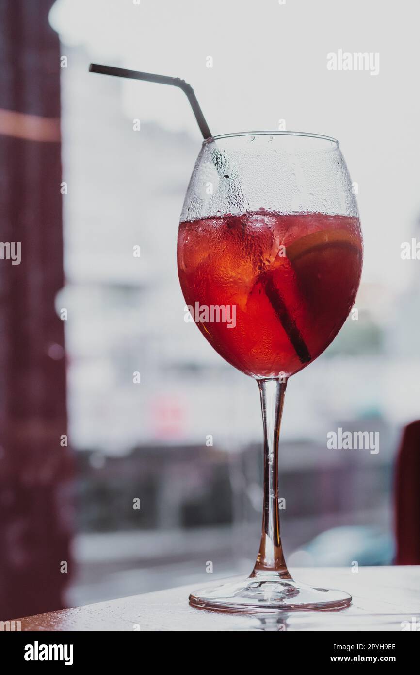 Image verticale verre à vin de boisson froide alcool cocktail boisson avec paille en plastique noir. Laisse tomber la condensation. Gros plan Banque D'Images