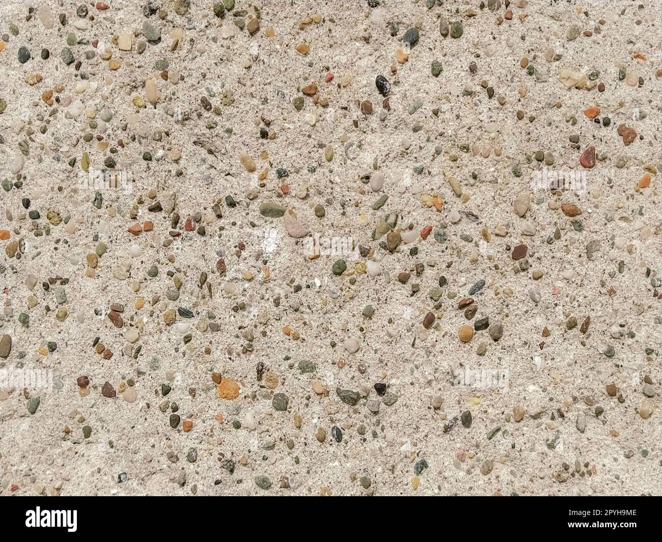 Surface en béton avec taches multicolores de petites pierres. Ton beige clair. Mur d'un bâtiment ou dalle de béton. Gros plan Banque D'Images