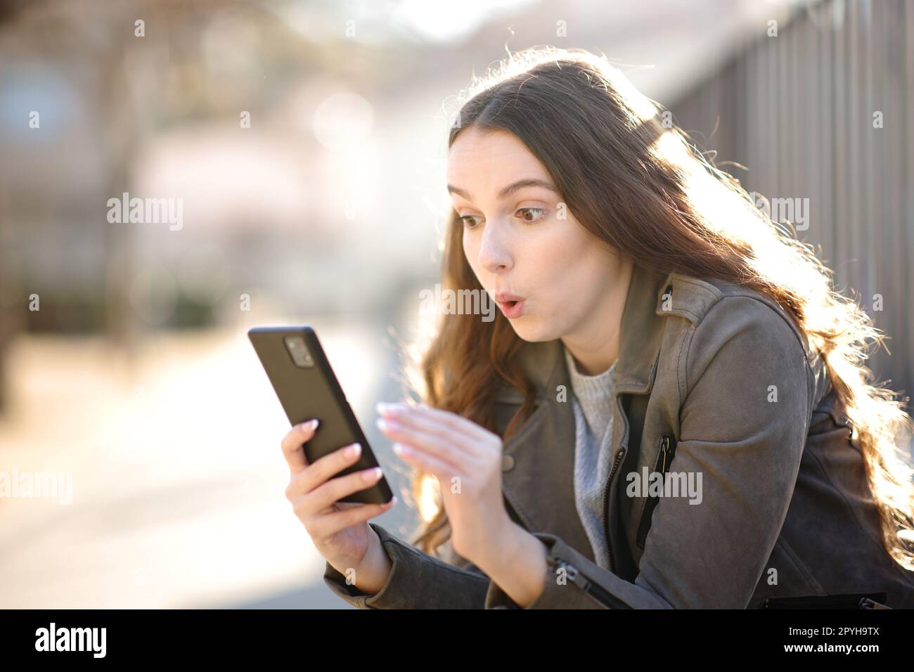 Femme surprise regardant son téléphone Banque D'Images