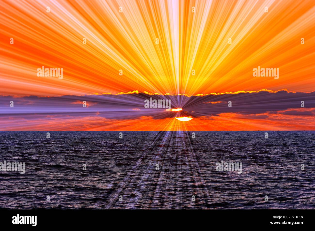 Un coucher de soleil sur l'océan avec des rayons du soleil émanant de l'arrière des nuages Banque D'Images