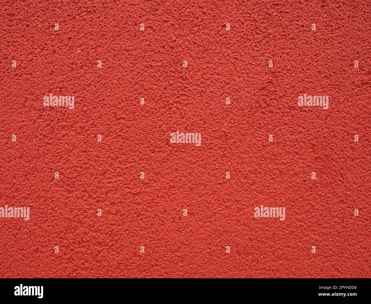 Fond, texture de plâtre de ciment de couleur rouge. Plâtrage des locaux internes et des façades externes des bâtiments. Intérieur en rouge. Banque D'Images