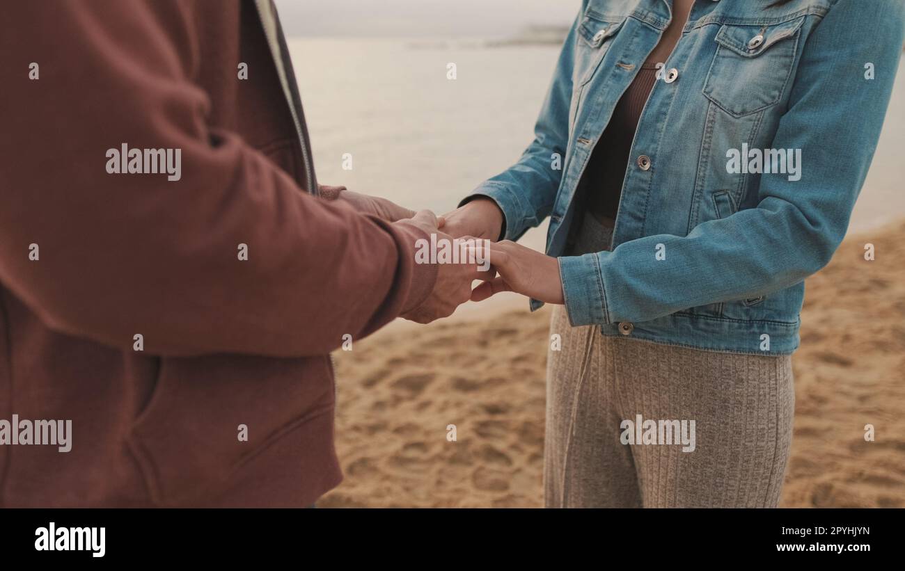 Gros plan des mains de l'homme et de la femme. Couple aimant tenant la main sur le paysage marin Banque D'Images