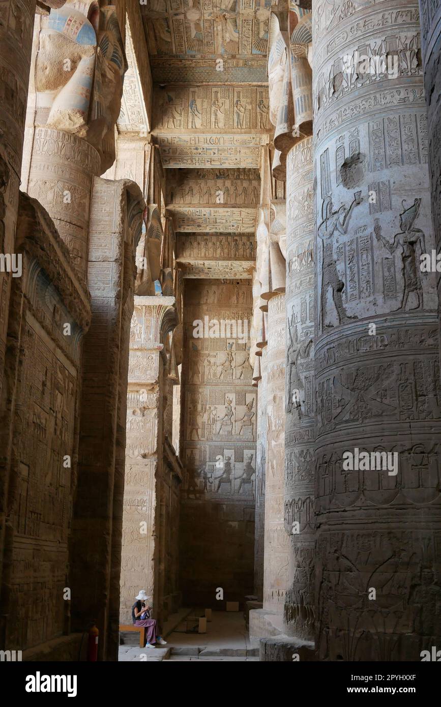 Femme assise à l'intérieur du Temple de la déesse Hathor à Dendara en Égypte Banque D'Images