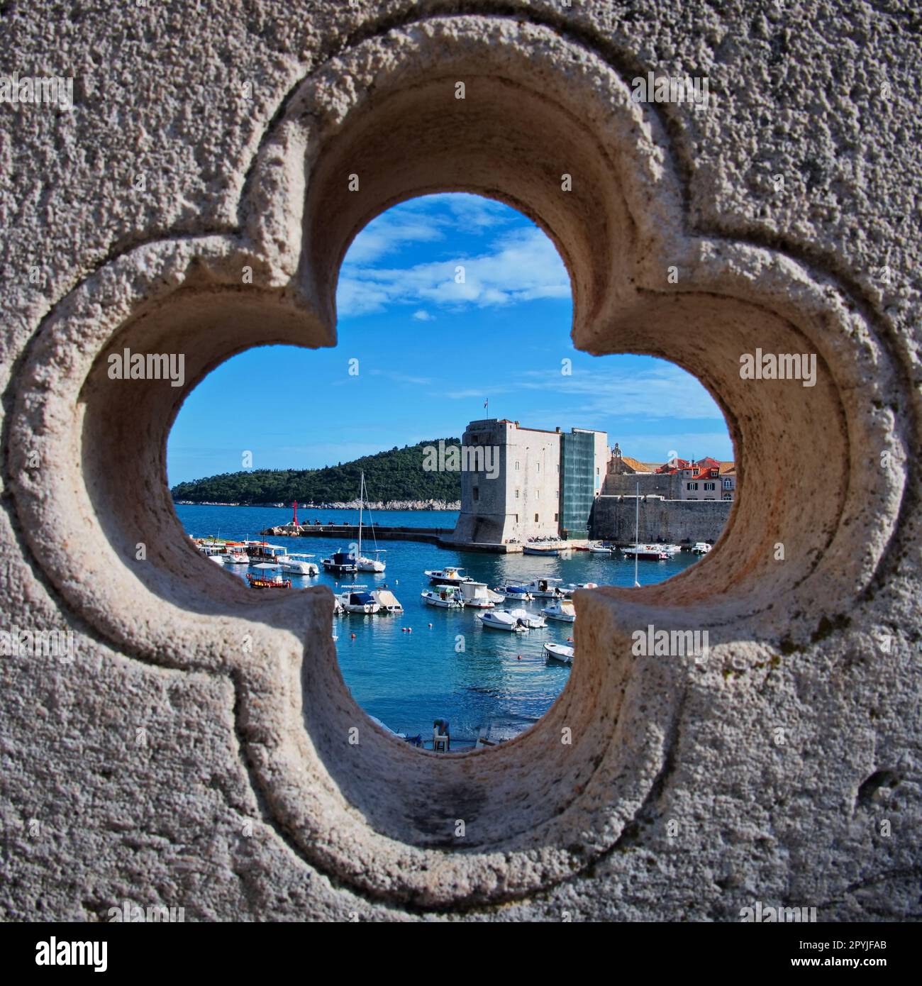 Le vieux port de Dubrovnik vu à travers une rosace dans le mur Banque D'Images