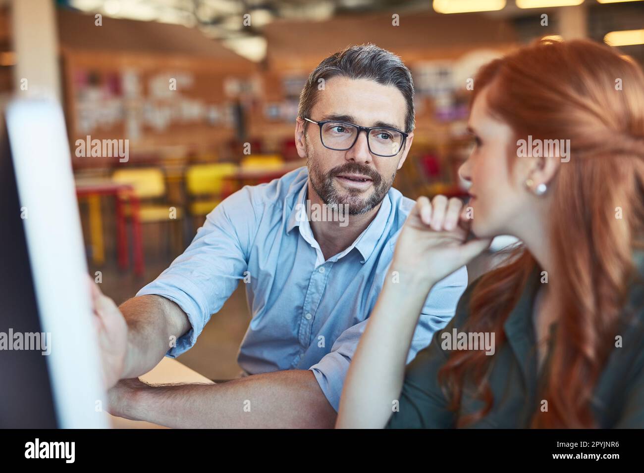 Travailler ensemble sur un plan global. deux concepteurs travaillent ensemble sur un ordinateur dans un bureau. Banque D'Images