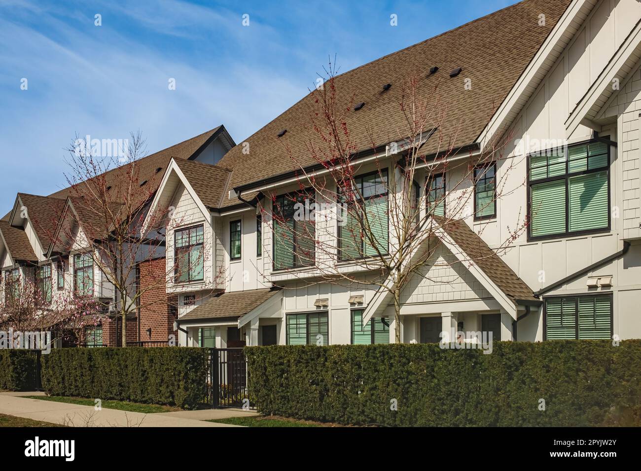 Un quartier parfait. Maisons en banlieue à Spring en Amérique du Nord. Immobilier extérieur Maisons en façade par une journée ensoleillée. Maisons de ville avec belle terre Banque D'Images