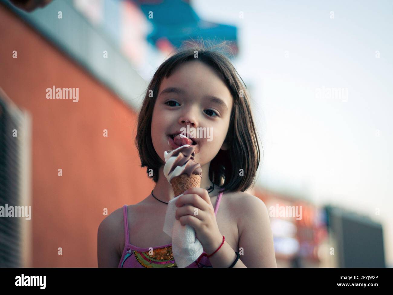 Petite fille mangeant de la glace à l'extérieur Banque D'Images