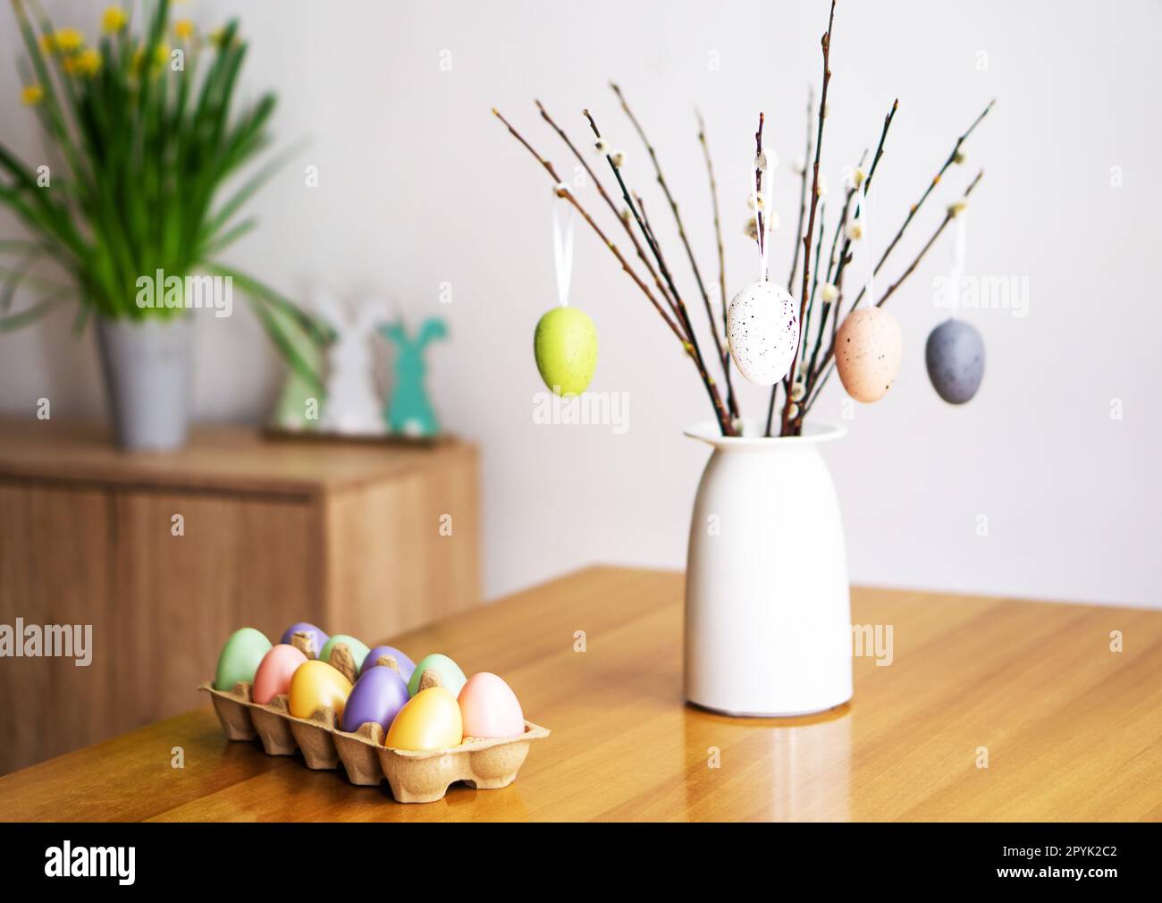 Décoration de Pâques avec un bouquet de branches de saule avec des œufs de couleur, des fleurs et des lapins. Banque D'Images
