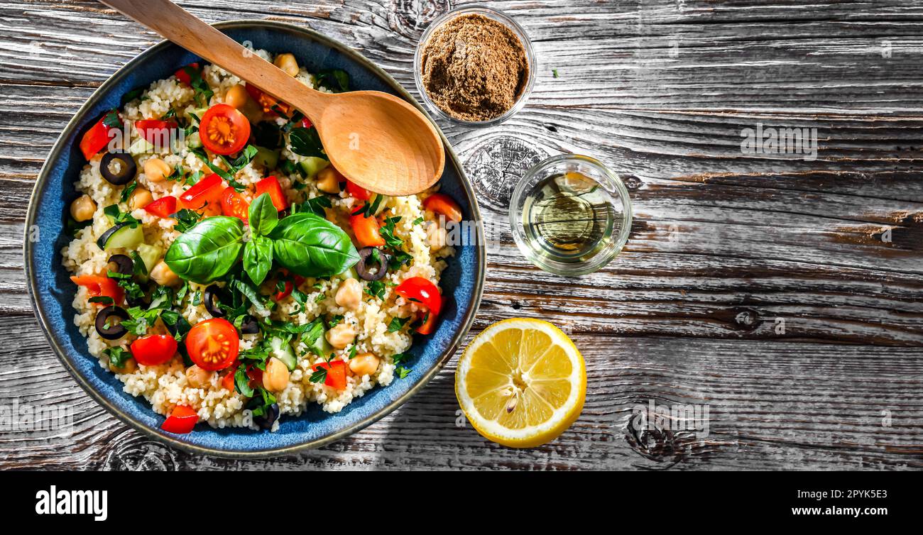 Une assiette de couscous servie avec des légumes et des pois chiches Banque D'Images