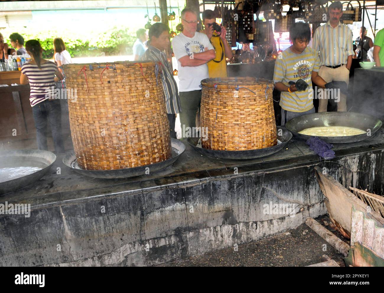 Un homme thaïlandais cuisant des œufs et du porc freGrant ragoût dans un style traditionnel au marché ferroviaire haut en couleur de Mae Klong, au sud-ouest de Bangkok, en Thaïlande. Banque D'Images