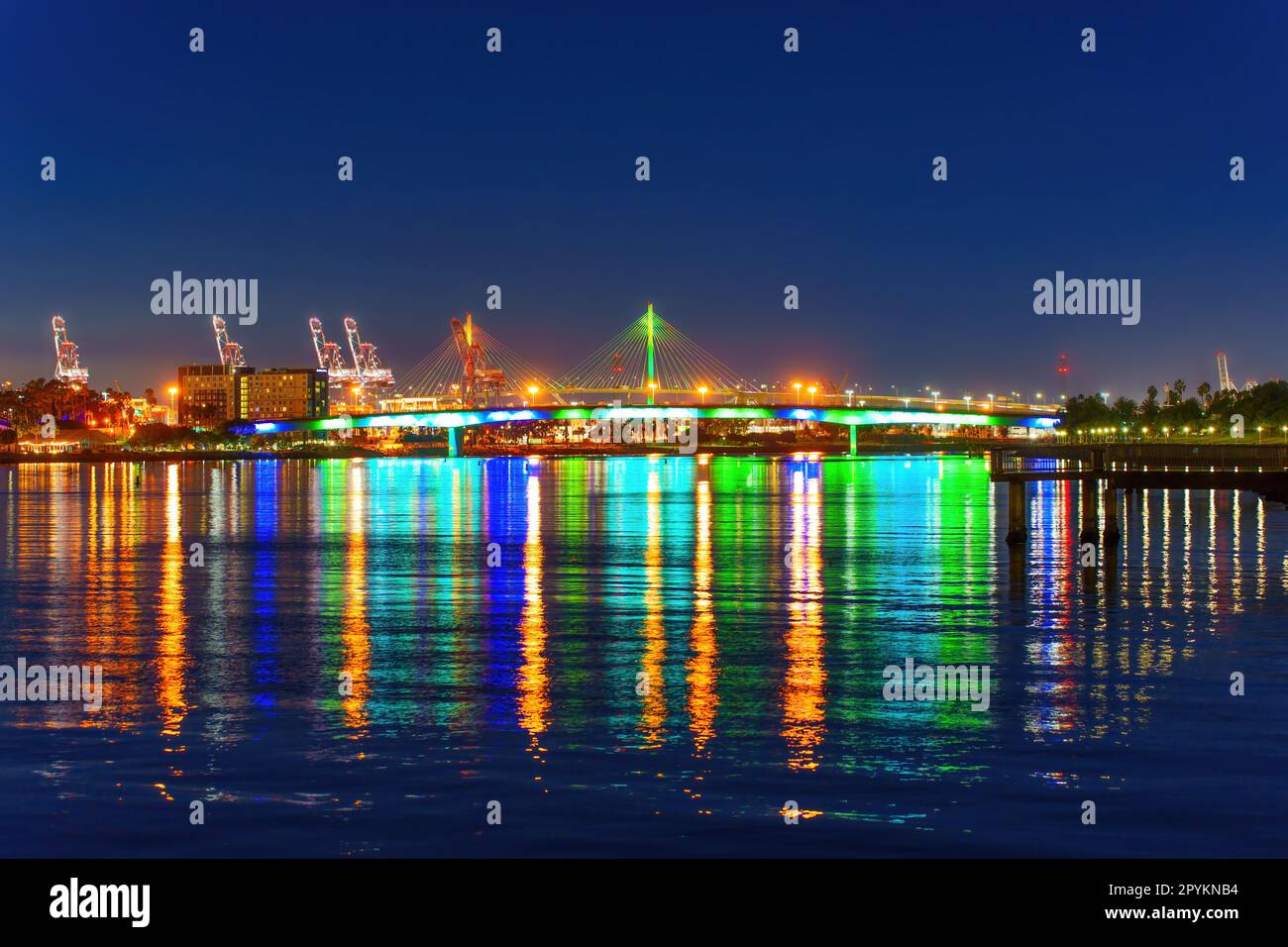 Queensway Bridge à long Beach, Californie, brille de mille feux la nuit, en jetant des reflets dans l'eau en contrebas. Banque D'Images