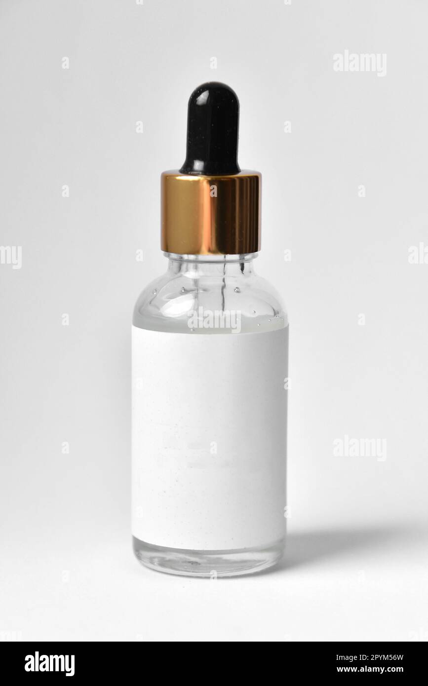 Modèle d'étiquette vierge de flacon en verre sur fond blanc. Étiquette vide de la maquette de verre compte-gouttes. Bouteille d'huile essentielle avec pipette, soin du visage Banque D'Images