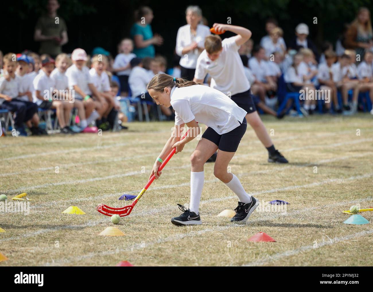 Jeune fille dans une course de slalom de hockey, School Sports Day, Essex, Angleterre Banque D'Images