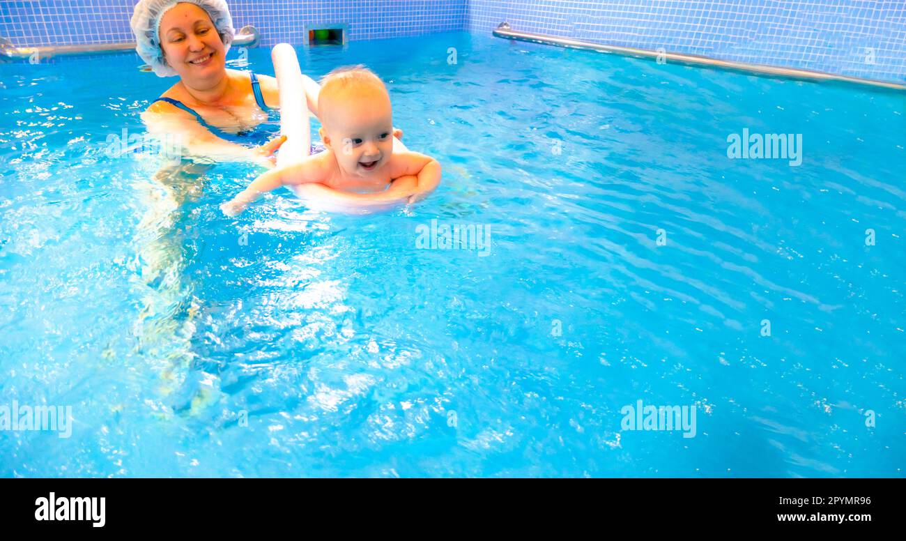 Adorable petite fille appréciant nager dans une piscine avec sa mère cours de développement