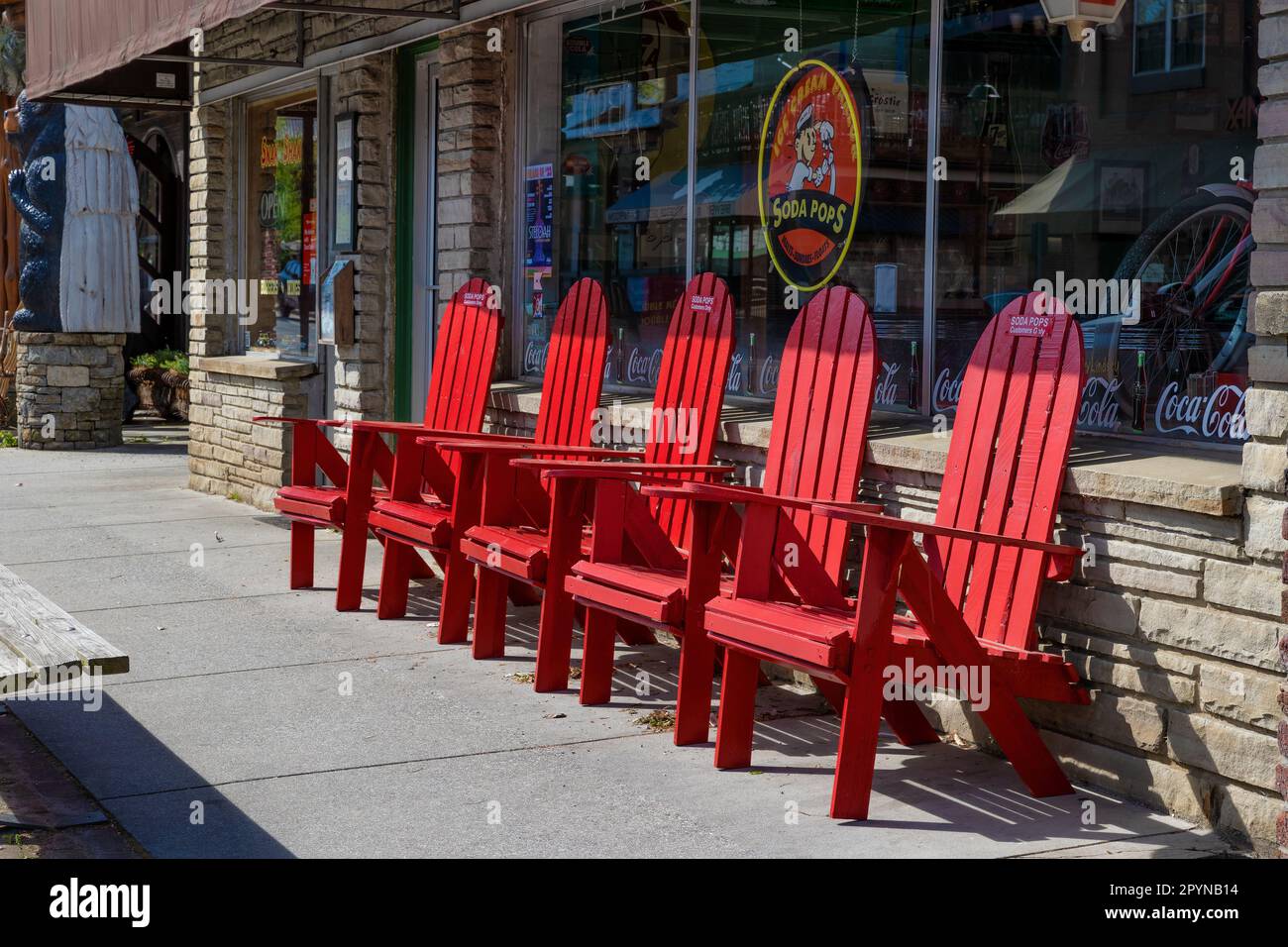 Bryson, Caroline du Nord, Etats-Unis - 19 avril 2023: Centre-ville où les chaises rouges Adirondack sont alignées offrant le repos pour les fatigués. Banque D'Images