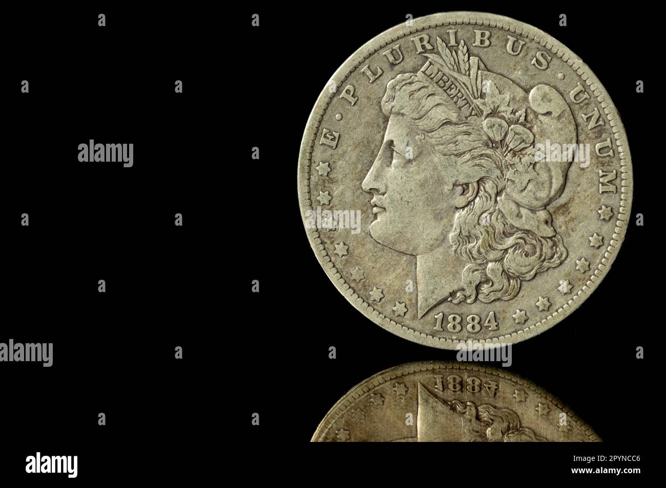 1884 Morgan Silver Dollar contre fond noir avec réflexion Banque D'Images