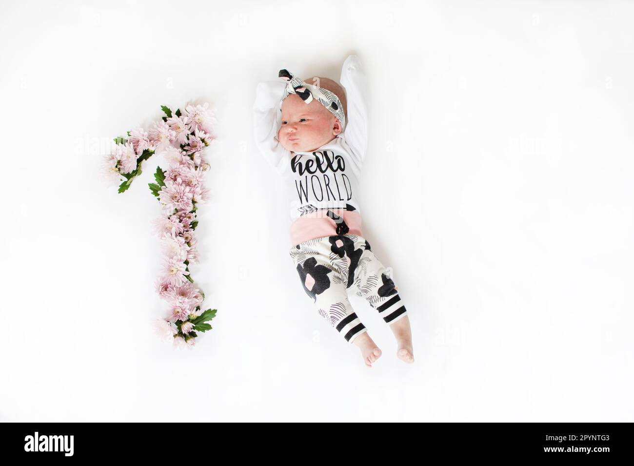 petite fille de 1 mois aux fleurs roses. Jalon bébé un mois. Nouveau-né d'un mois. Anniversaire enfants Banque D'Images