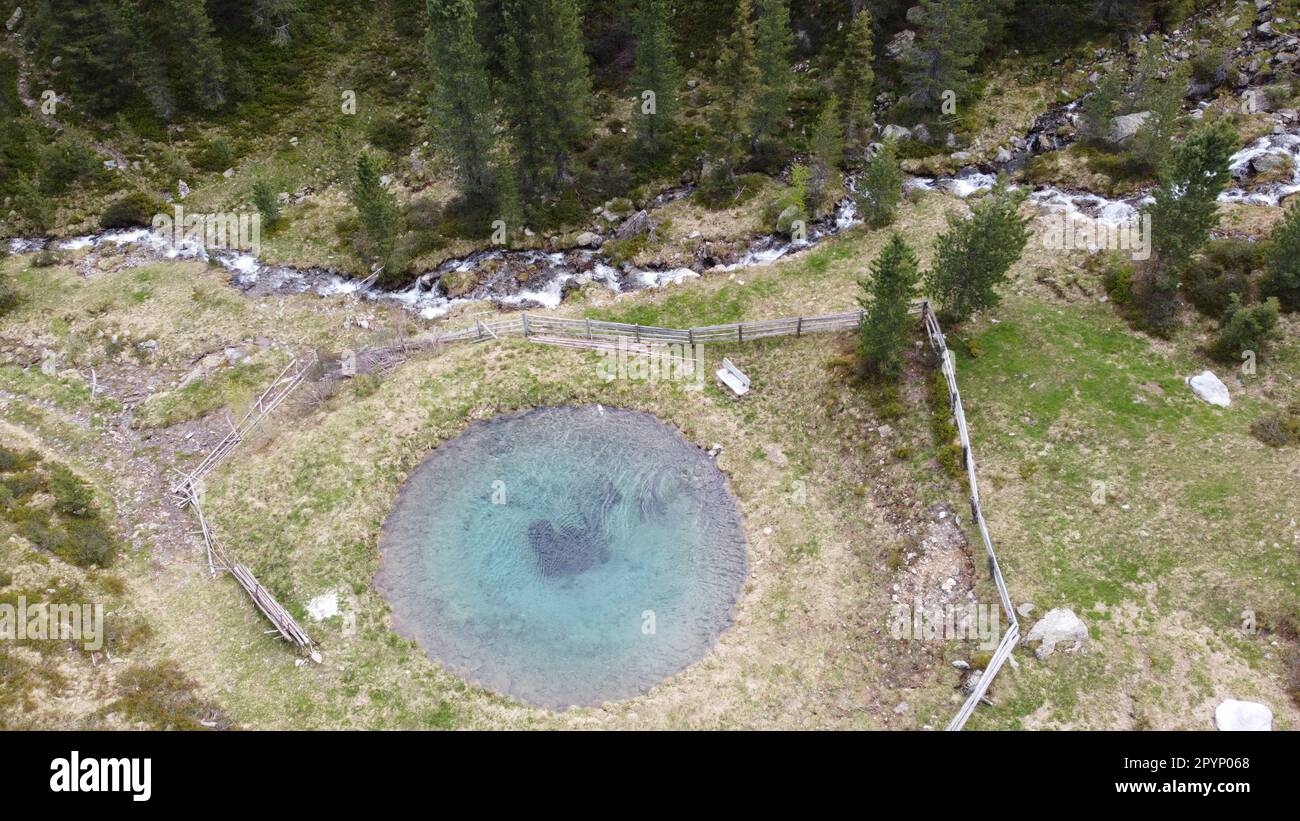 Kleiner Löschteich, mit türkiesbauem Wasser, insmitten einer malerischen Bergwelt in Südtirol- Luftbildaufnahme Banque D'Images