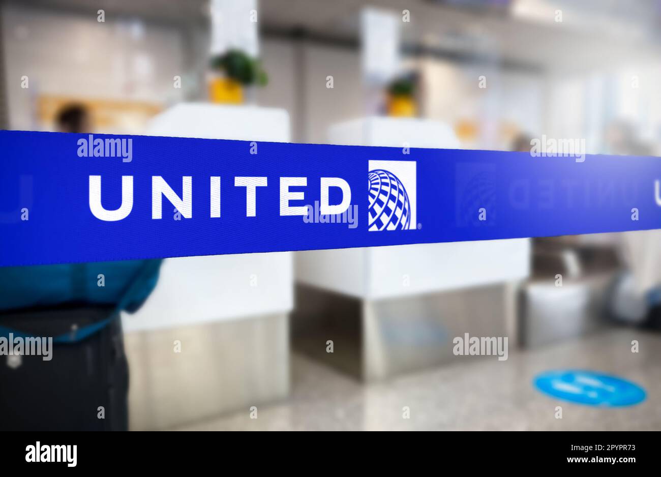 Chicago, États-Unis, janvier 2023 : barrière de ceinture rétractable bleue avec logo blanc United Airlines. United est une grande compagnie aérienne américaine. Sécurité des voyages et de l'aéroport. Banque D'Images