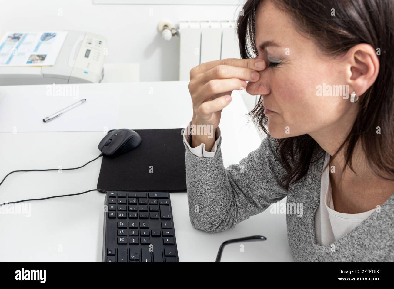 Conséquences du travail excessif : la lutte d'une femme avec la fatigue et le stress Banque D'Images