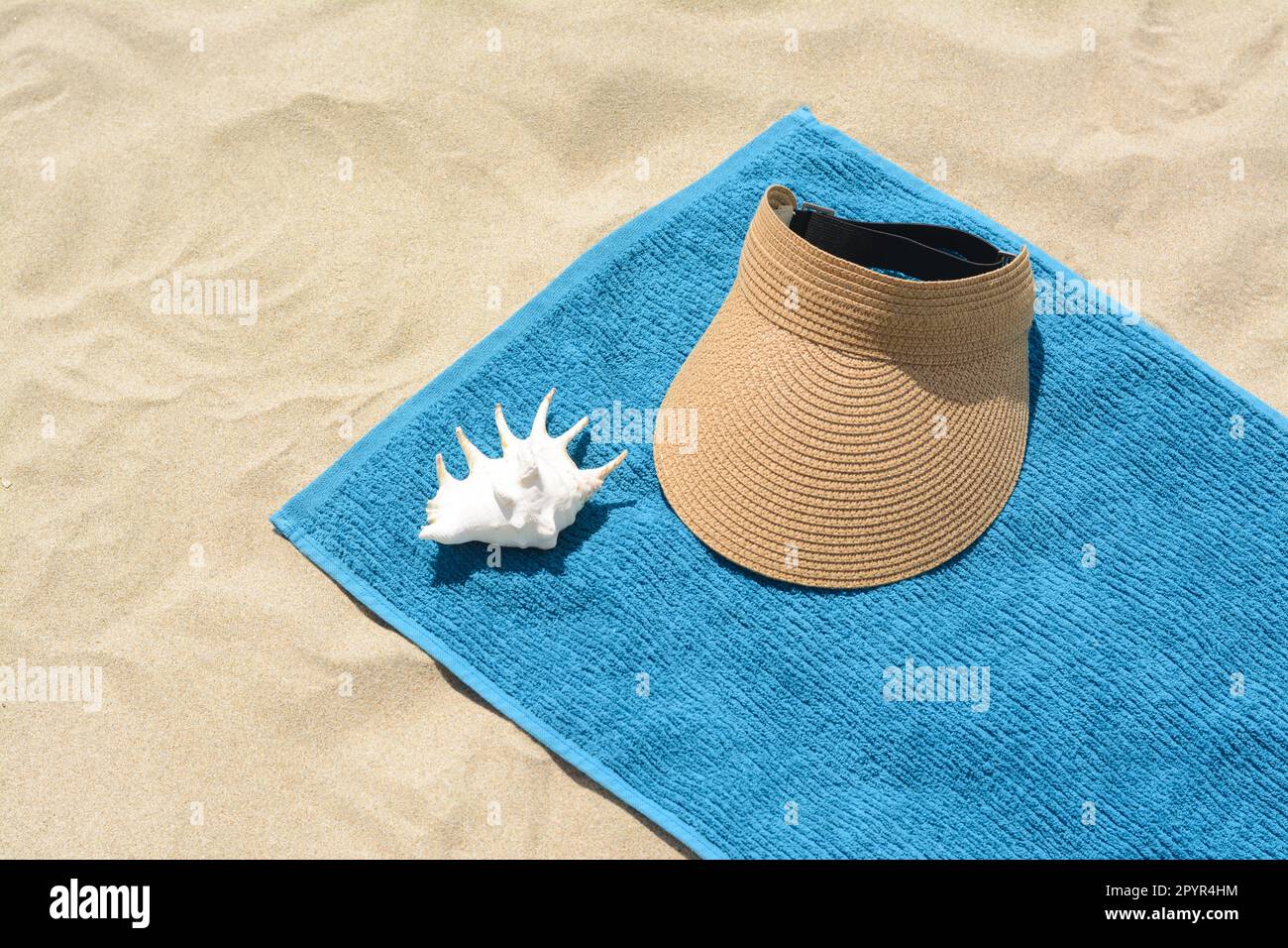 Serviette, chapeau de pare-soleil en paille et fond de mer sur sable.  Accessoires de plage Photo Stock - Alamy