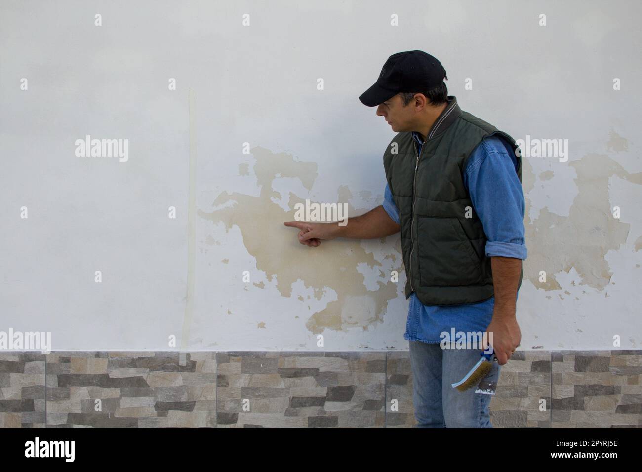 Image d'un ingénieur de construction illustrant les dommages causés à un mur de briques par des problèmes d'humidité. Réparation en raison de l'humidité qui monte Banque D'Images