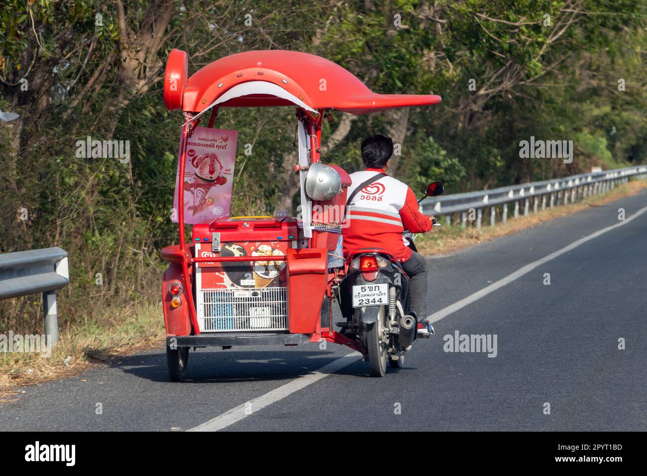 THAÏLANDE, JANVIER 21 2023, Un homme conduit une moto avec un chariot pour la vente de produits surgelés ALGIDA, vue arrière Banque D'Images
