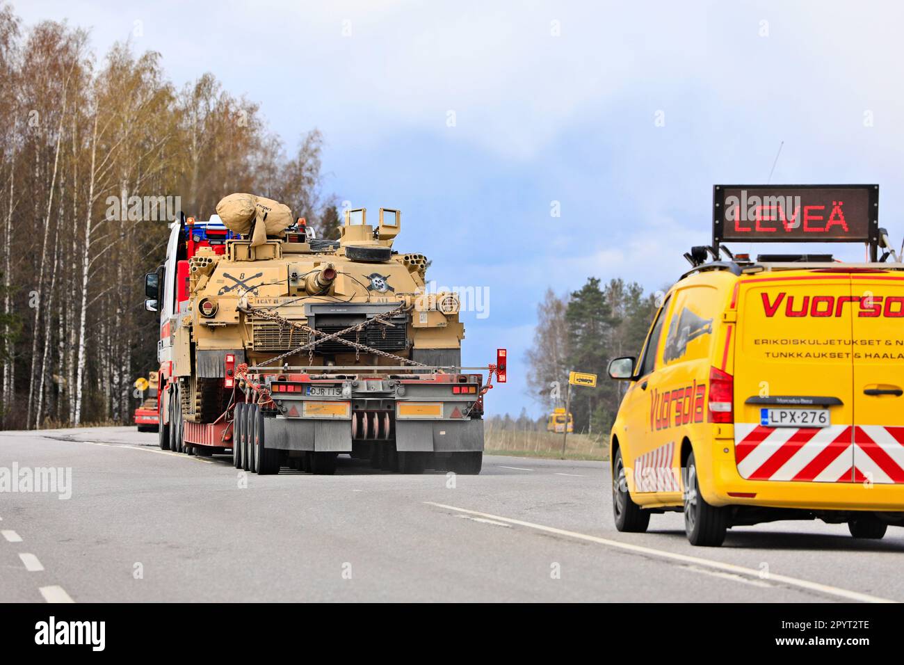 Transport de charge exceptionnel du char militaire américain M1 Abrams en circulation avec un véhicule d'escorte. Convoi de 3 transports. Lieto, Finlande. 28 avril 2023. Banque D'Images