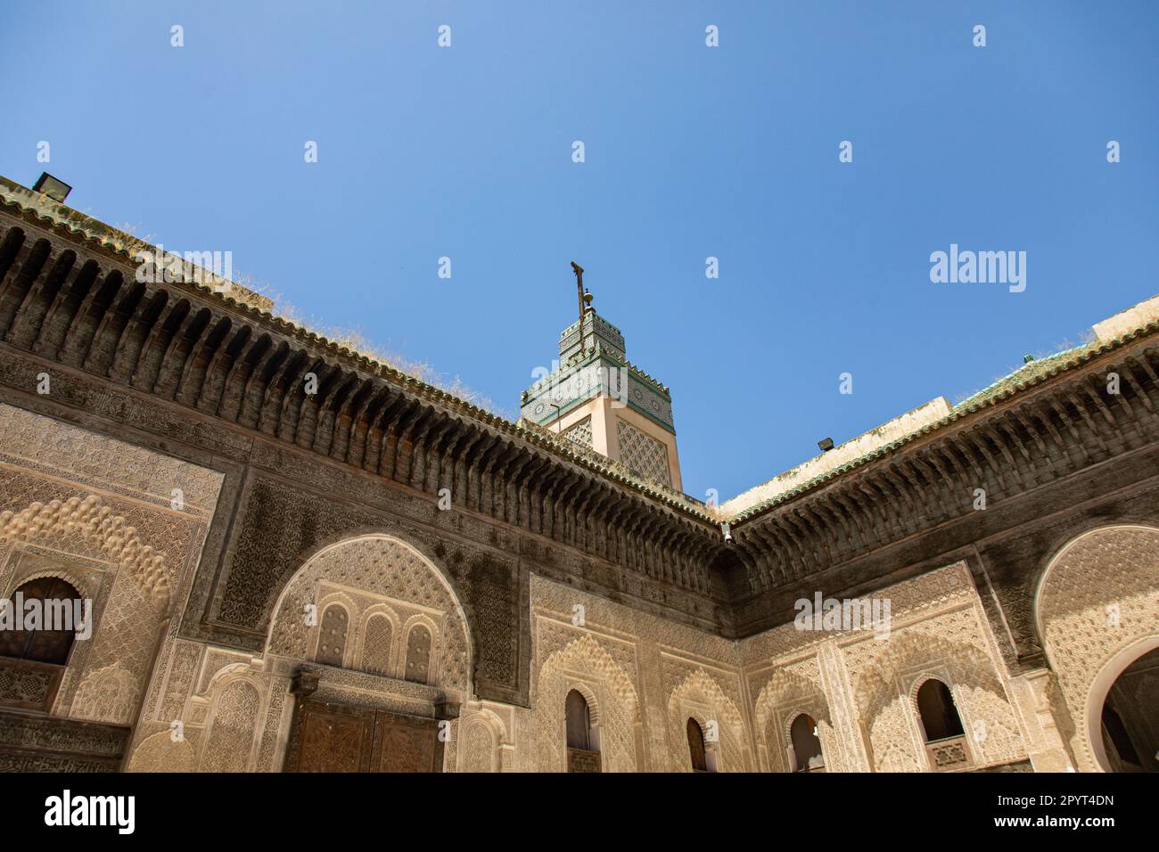 Fez, Maroc 2022: Bou Inania Madrasa dans la Fès el-Bali, la vieille médina, avec des rues étroites historiques et traditionnelles avec des boutiques du souk (suq) Banque D'Images