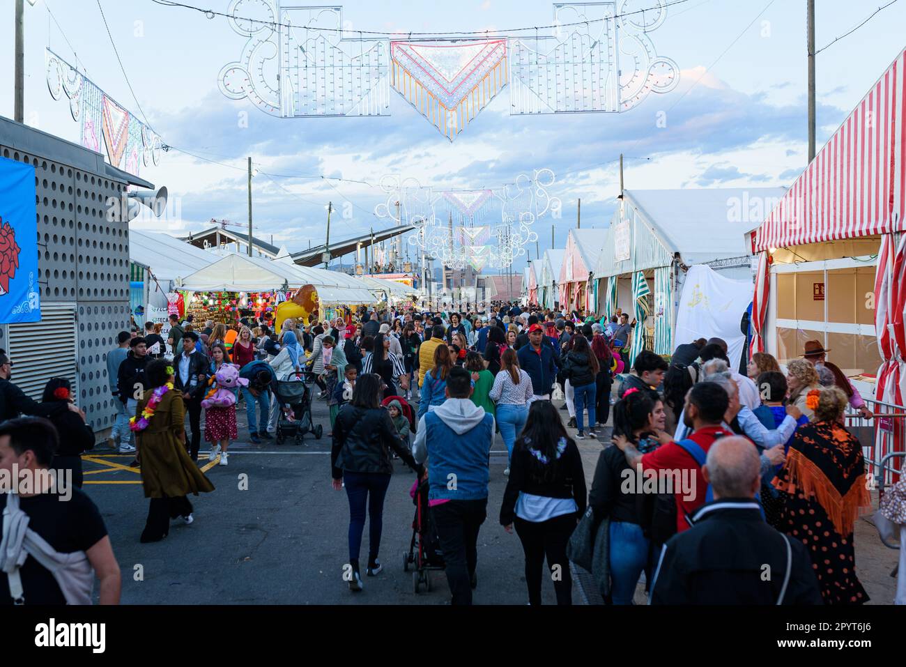 On voit des gens marcher parmi les étals pendant les célébrations de la foire « Feria de Abril » dans le parc du Forum. La foire, connue sous le nom de foire de Séville, est originaire Banque D'Images