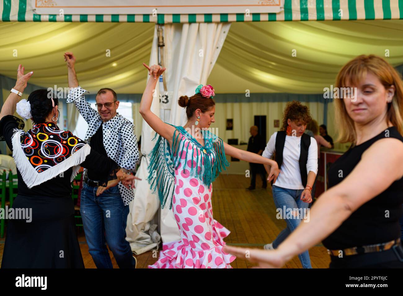 Les femmes vêtues de robes andalouses traditionnelles dansent le flamenco lors des célébrations de la foire « Feria de Abril » dans le parc du Forum. La foire, connue sous le nom de Séville Banque D'Images