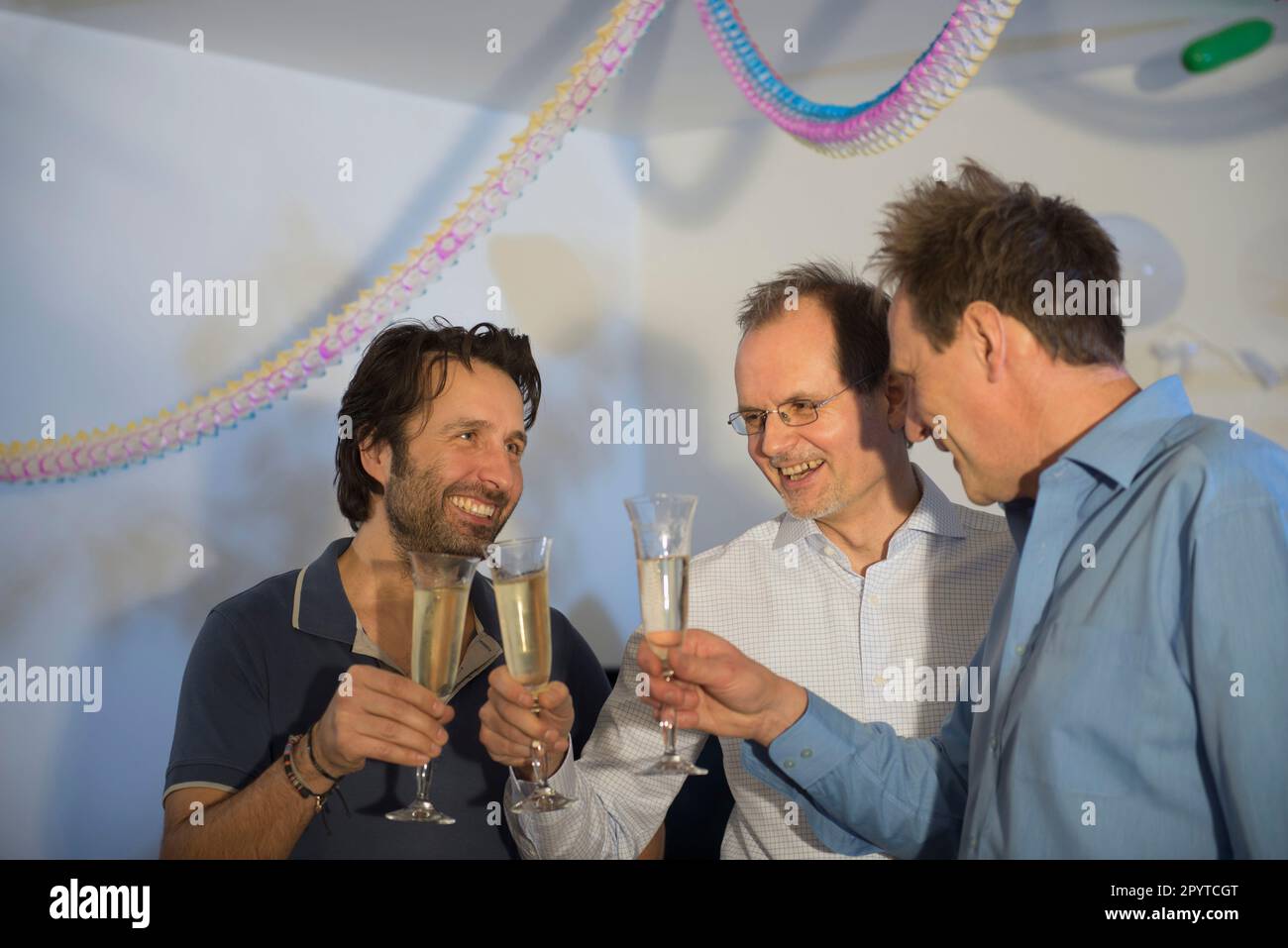 Des hommes qui font des toasts de fête avec du vin mousseux Banque D'Images